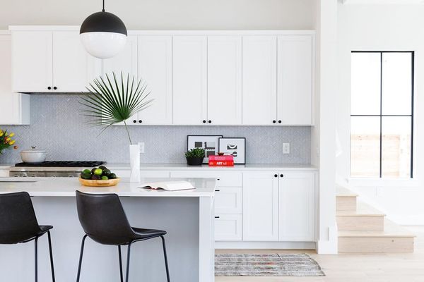 明亮的白色厨房与棕榈叶装饰。