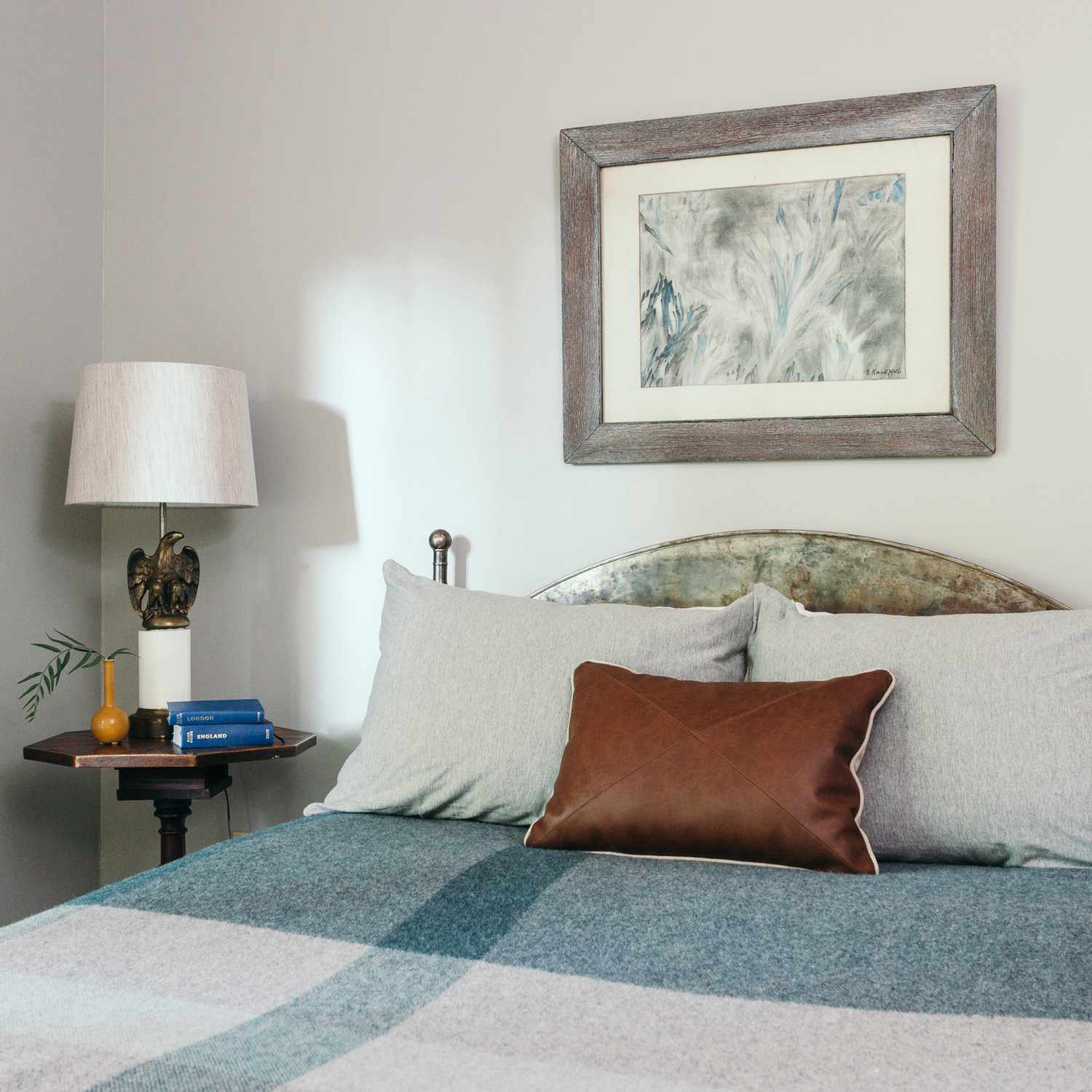 一间带格子毯子和皮革枕头的卧室