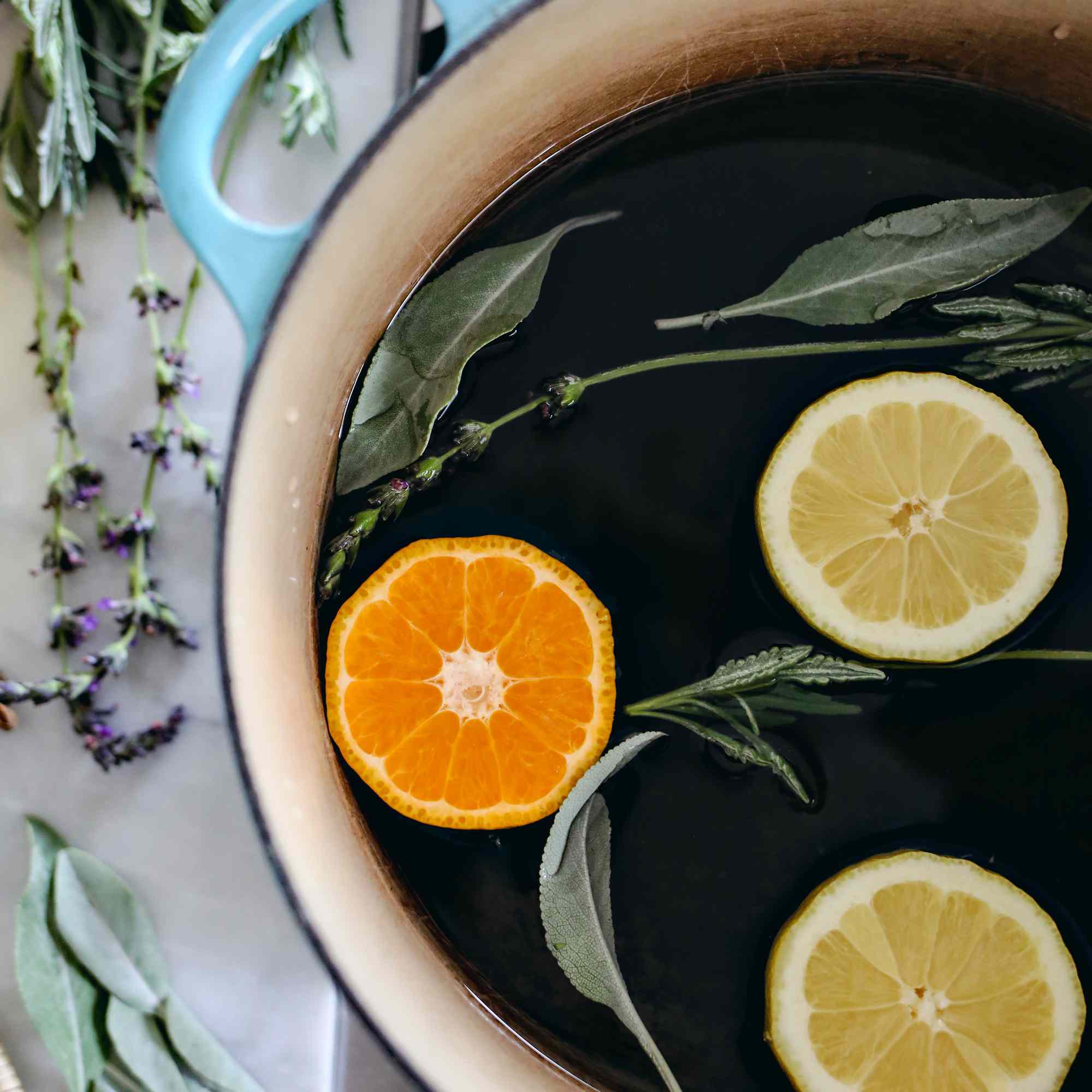 头顶上的锅在炉子上充满了柑橘类水果和新鲜的香草