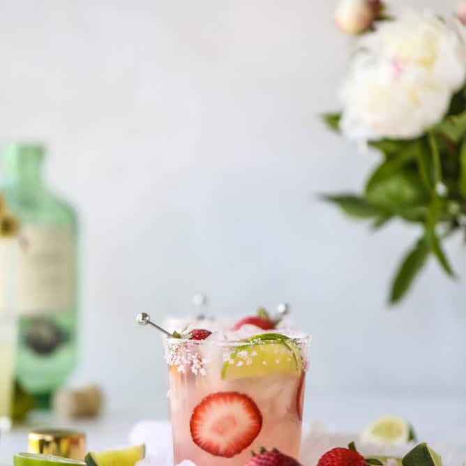 玛格丽塔草莓和柠檬。鲜花的背景。