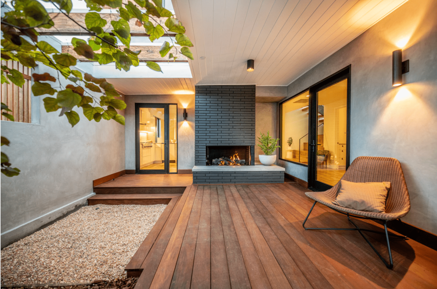 木镶边的露台上装饰着一座黑色砖砌壁炉