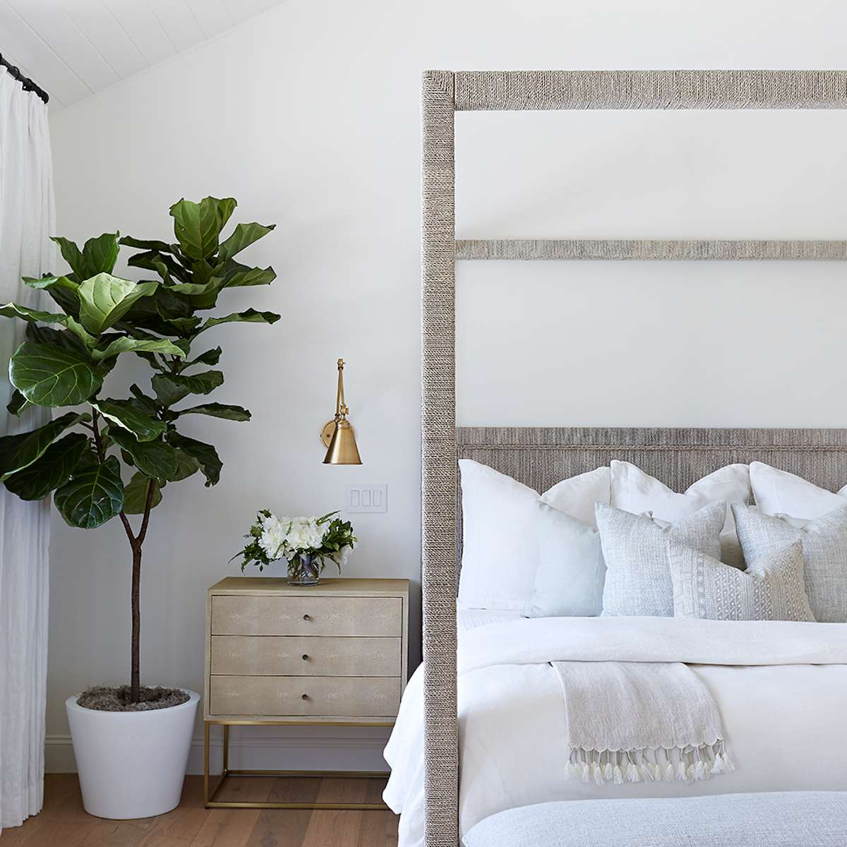 一间极简主义的卧室，带有一个编织的顶棚床架