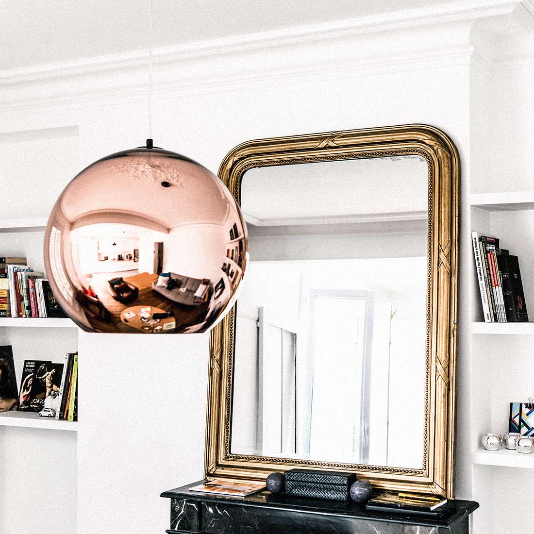 大理石壁炉架上的古董金镜子。