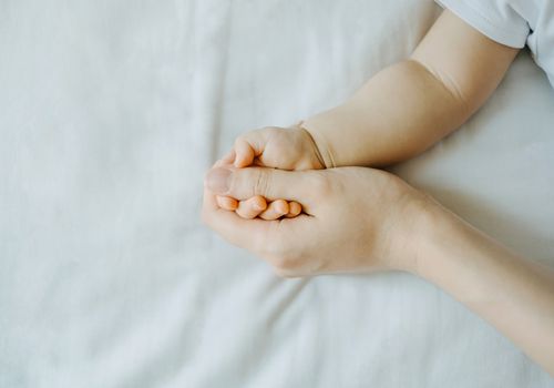 妈妈牵着新生儿的手