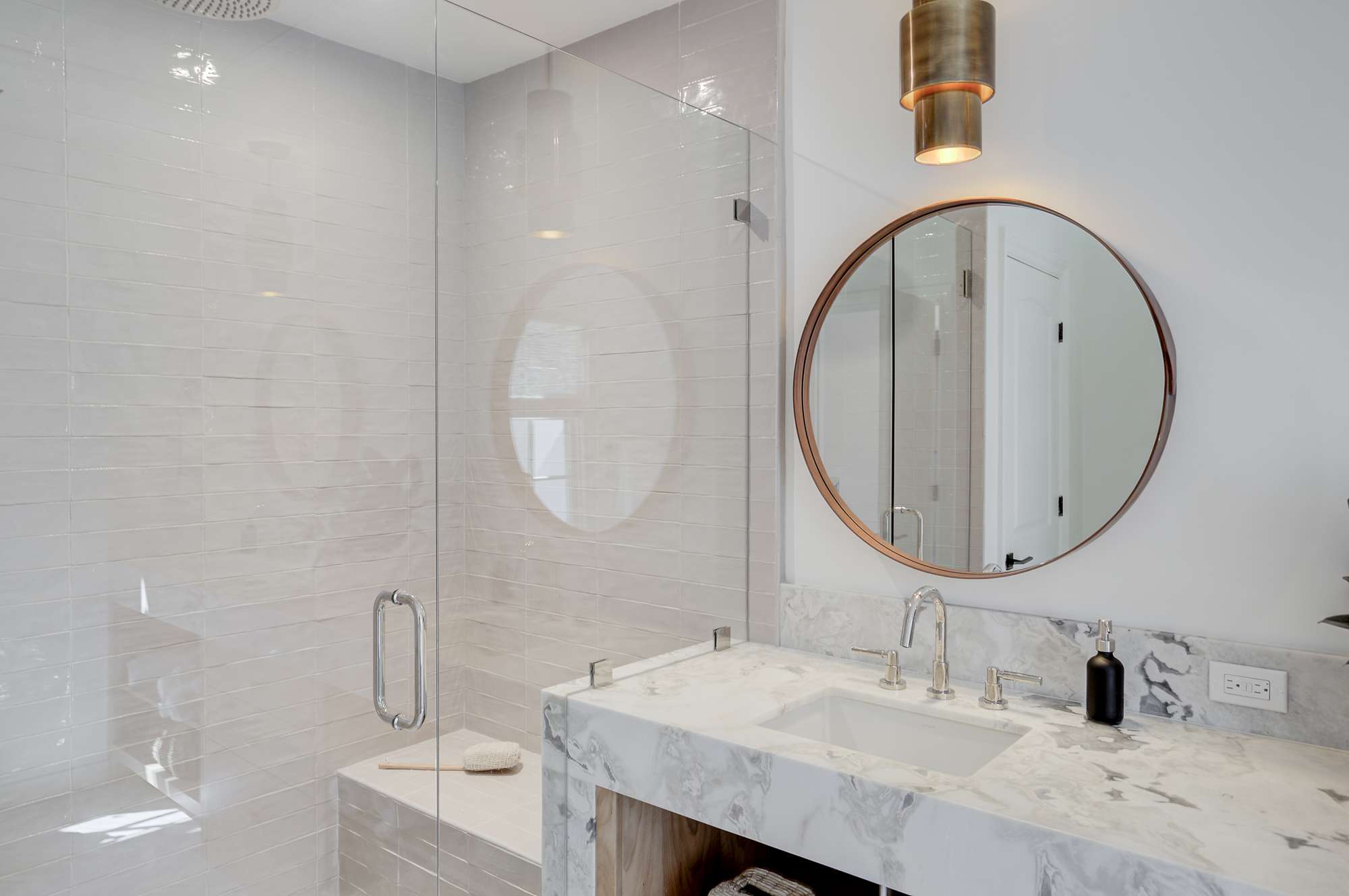 有大理石台面和玻璃淋浴间的梳妆台。