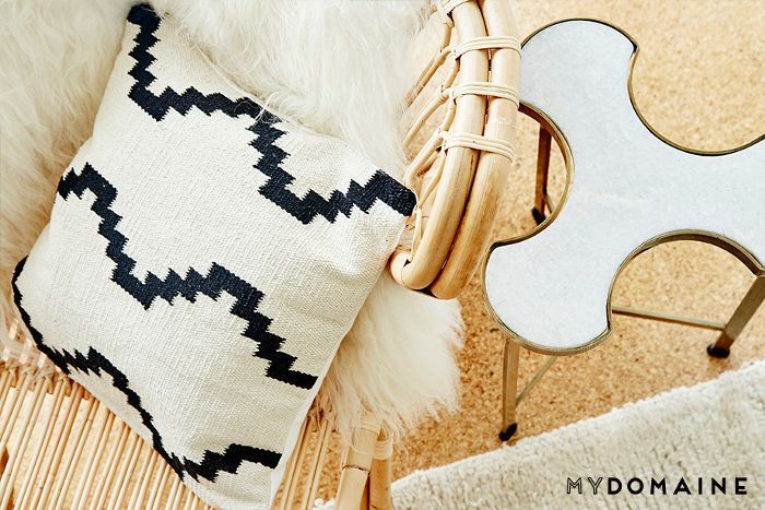 一个黑白相间的枕头，带毛皮包的柳条椅，还有曲线形的边桌