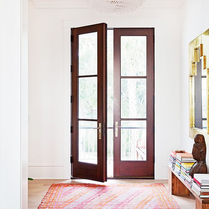 在立德家庭自然光线充足的房间设有落地到天花板的门和一个大型的粉红色和橙色的地毯