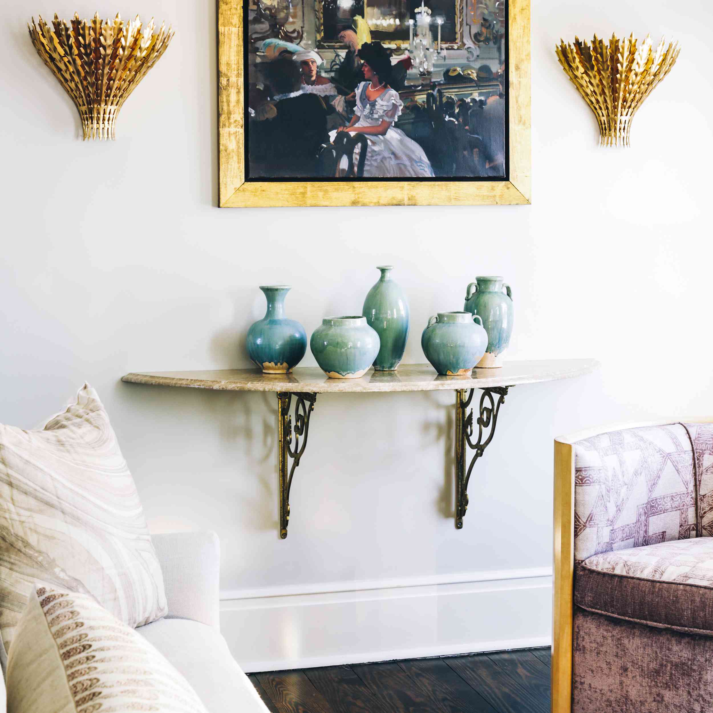 客厅的墙上挂着古董艺术品，两侧是金色的壁灯