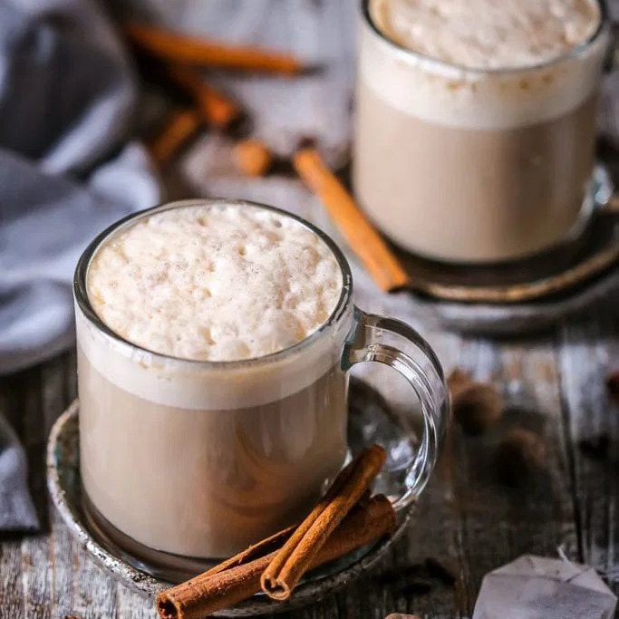 在玻璃水杯两个柴拿铁咖啡，淋上泡沫。