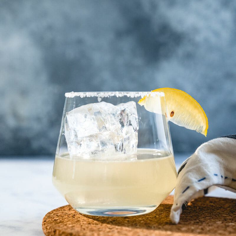 玛格丽塔装在一个用柠檬角装饰的玻璃杯里。