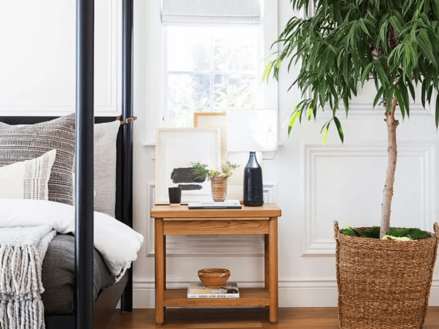 四柱床定位在左窗口，一个木制床头柜放置下方，并在它旁边，盆栽树