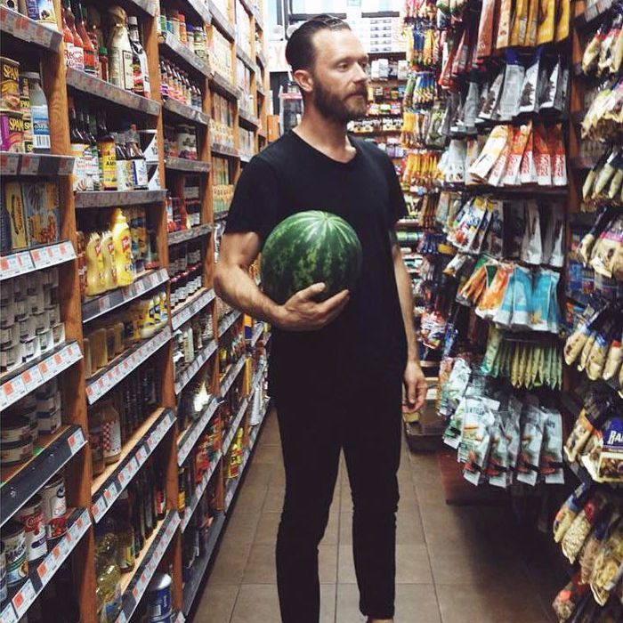 年轻男子携带在一家杂货店西瓜
