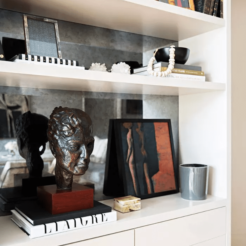 书架上的艺术品，被装饰性的物品和书籍包围着