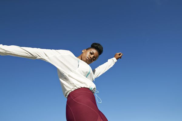 运动服的少妇反对一个清楚，晴朗的天空