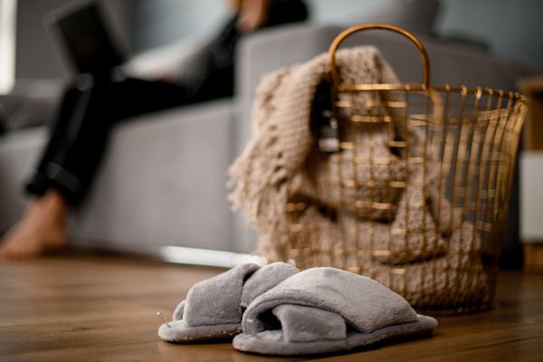 大金属柳条筐用在里面的被编织的毯子和附近的拖鞋