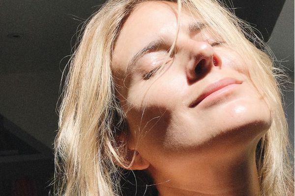 金发女人享受阳光照在脸上