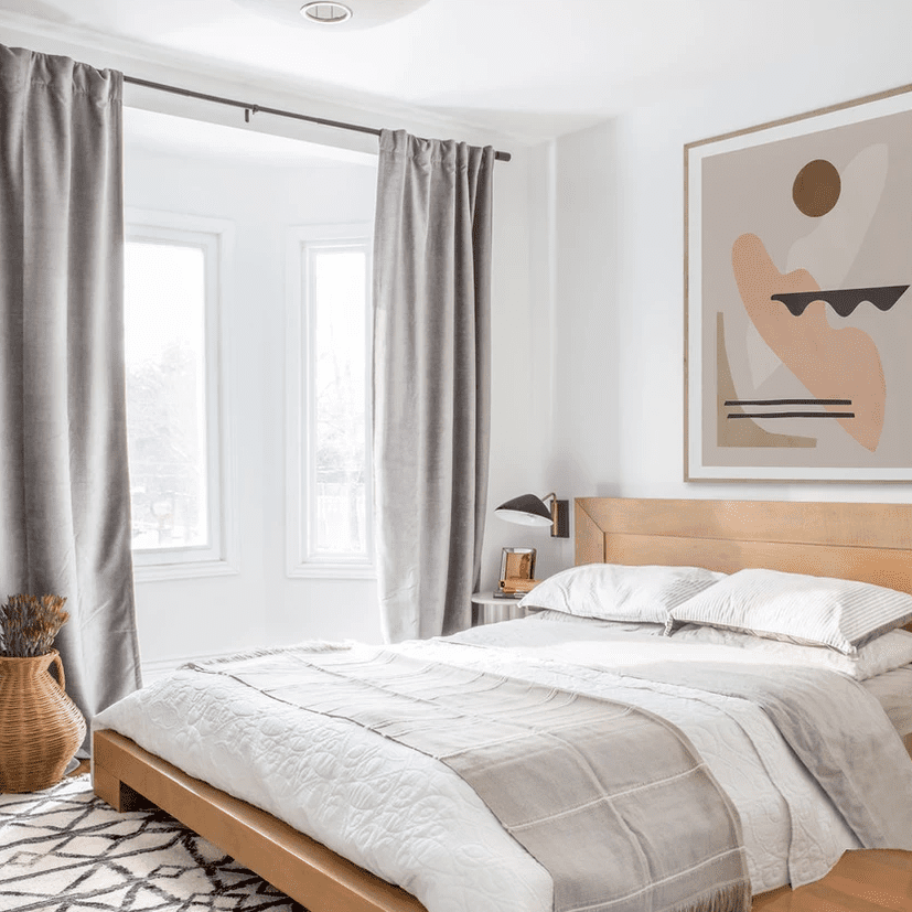 中性卧室，低床架和印刷艺术。