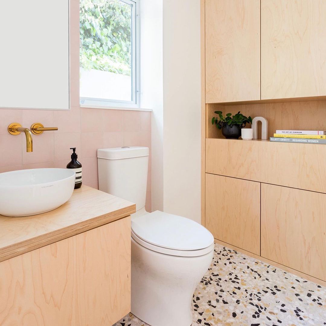 粉红色的浴室配有赤牙地板