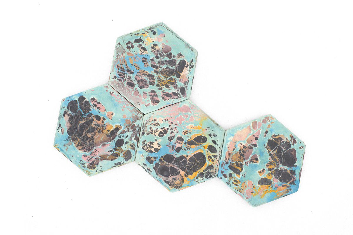 四个六角形的蓝色和粉红色的混凝土杯垫。