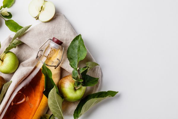 特写的苹果醋在瓶子上的白色背景-库存照片