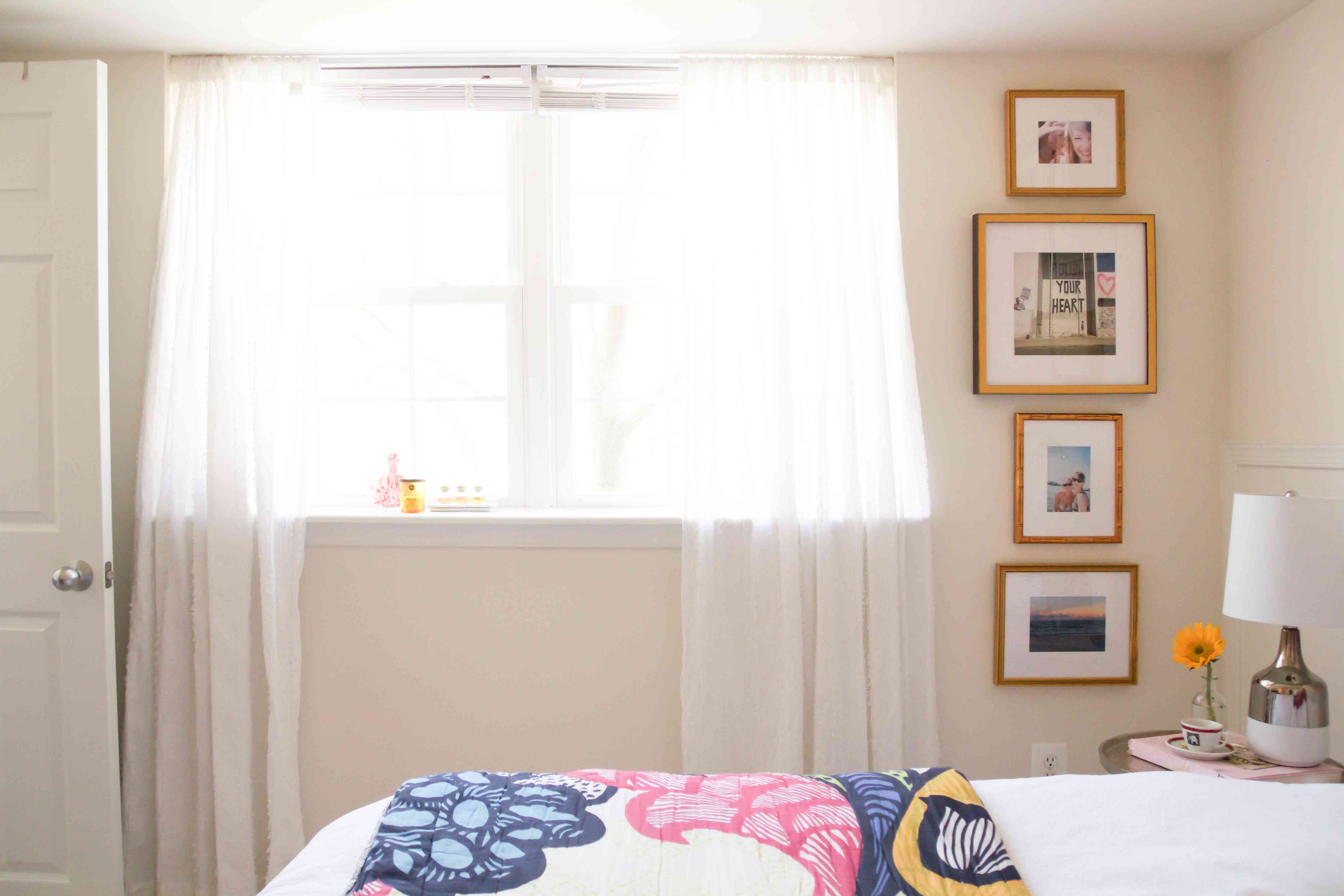 卧室里的一扇窗户旁边，竖着一排有相框的照片。