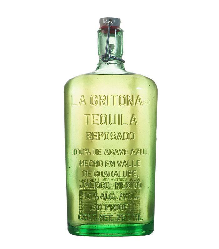 一瓶蓝绿色的龙舌兰酒，上面有压印的玻璃标签。