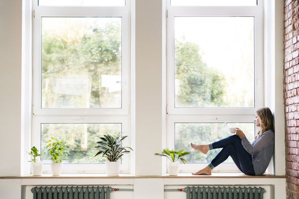 坐由窗口饮用的咖啡的妇女