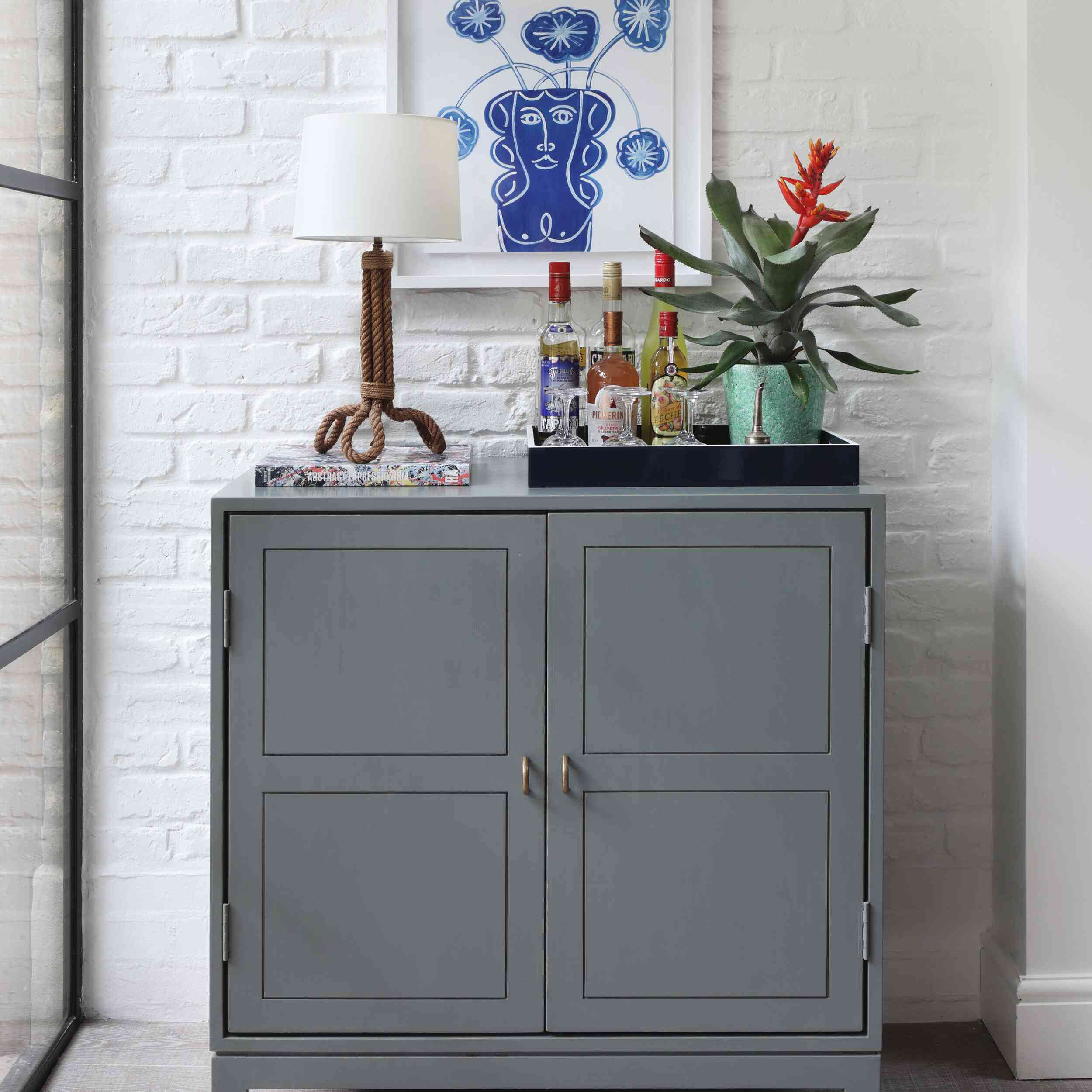 一个蓝灰色的酒吧柜，装满了一个充满酒的小托盘