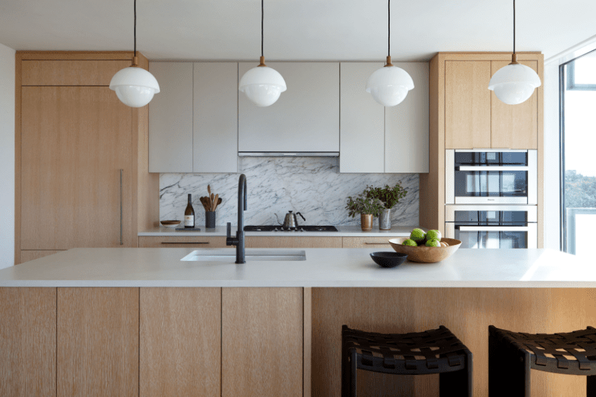 有黑白大理石和轻的木橱柜的厨房。