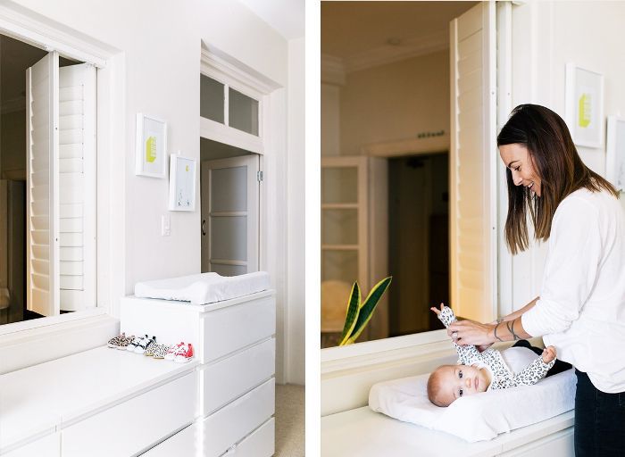 一个女人在换尿布的桌子上给孩子换尿布