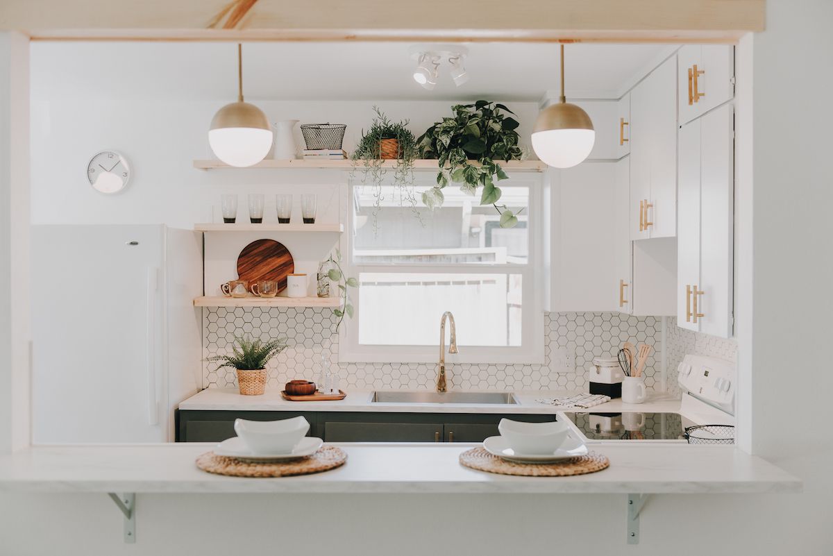 一个小型的白色厨房，其中包含声明灯光