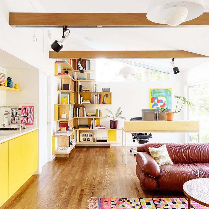 一个开放式的阁楼空间，有真皮沙发和黄色橱柜