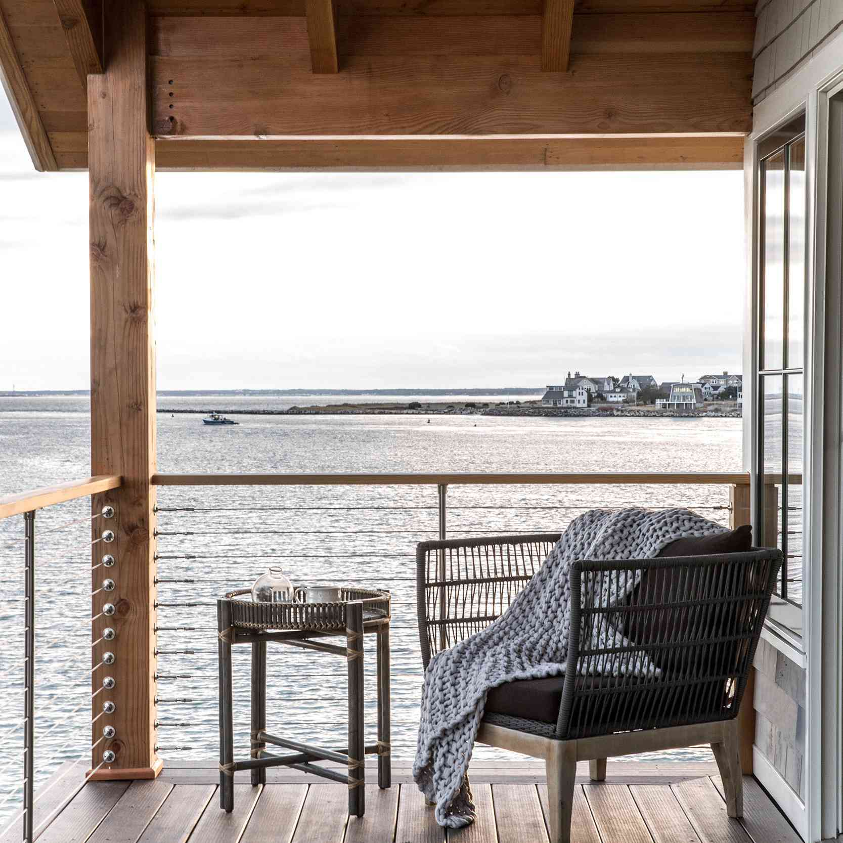 阳台上有一把椅子、一条毯子和一张小边桌