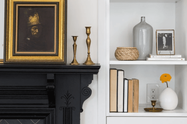 Decor on shelf and black fireplace mantle.v