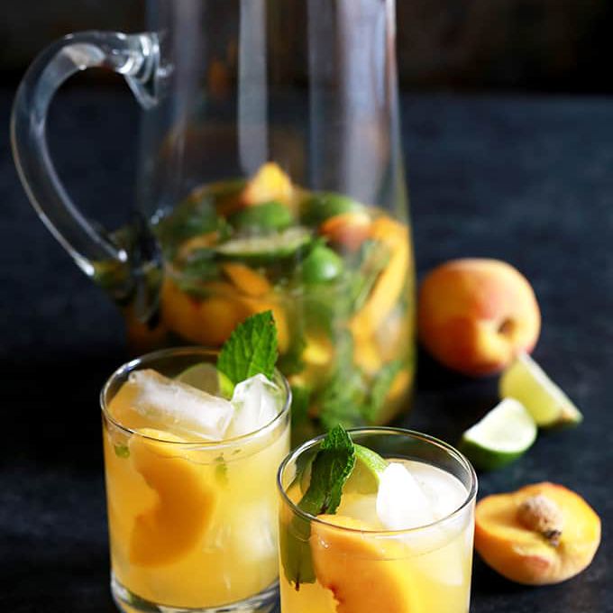 加了桃子和薄荷的鸡尾酒，放在加了冰的玻璃杯里。