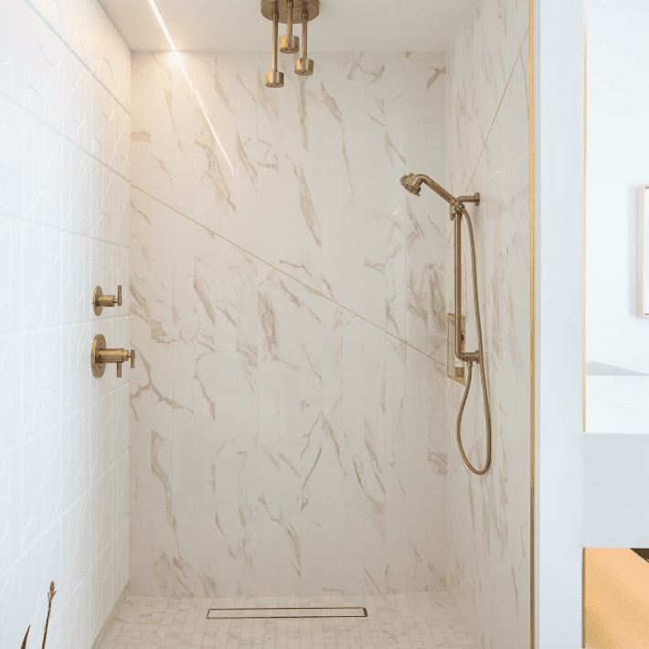 大理石淋浴间，金饰五金，包括一个看起来像枝形吊灯的三叉淋浴喷头