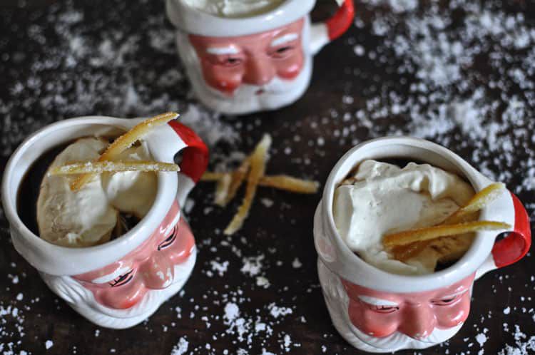 圣诞老人杯子里盛着鸡尾酒，配以蜜饯橘子皮。