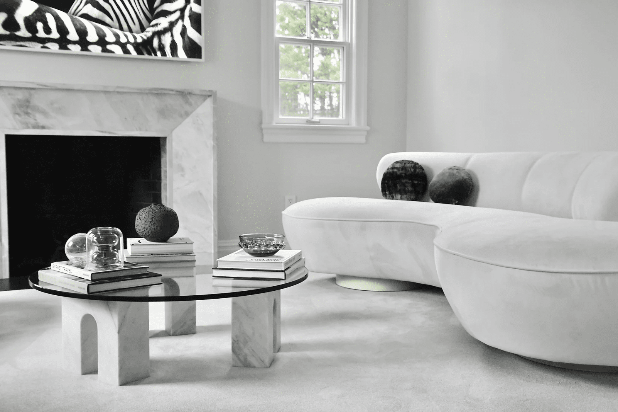 白色和浅灰色的客厅，有一座大理石壁炉和配套的咖啡桌