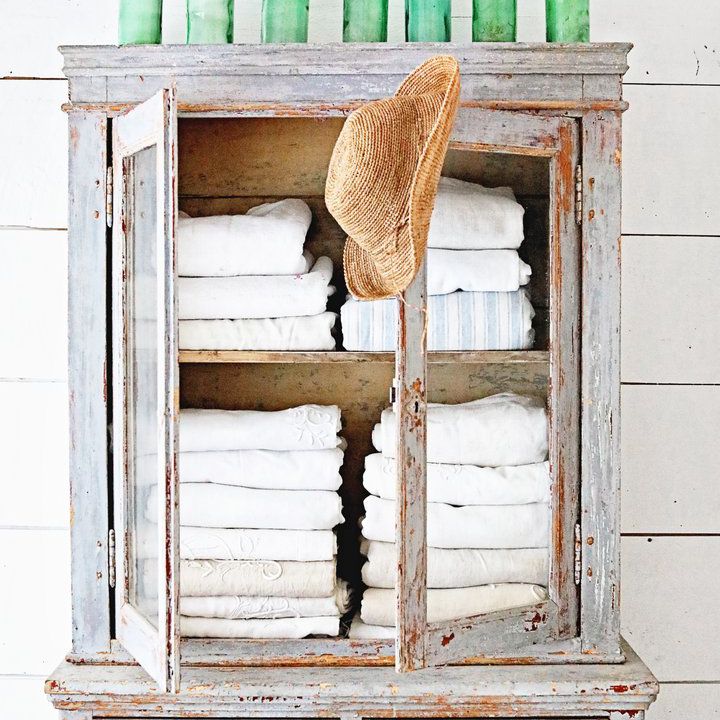 一个质朴的蓝色橱柜，上面放着几个古董玻璃瓶