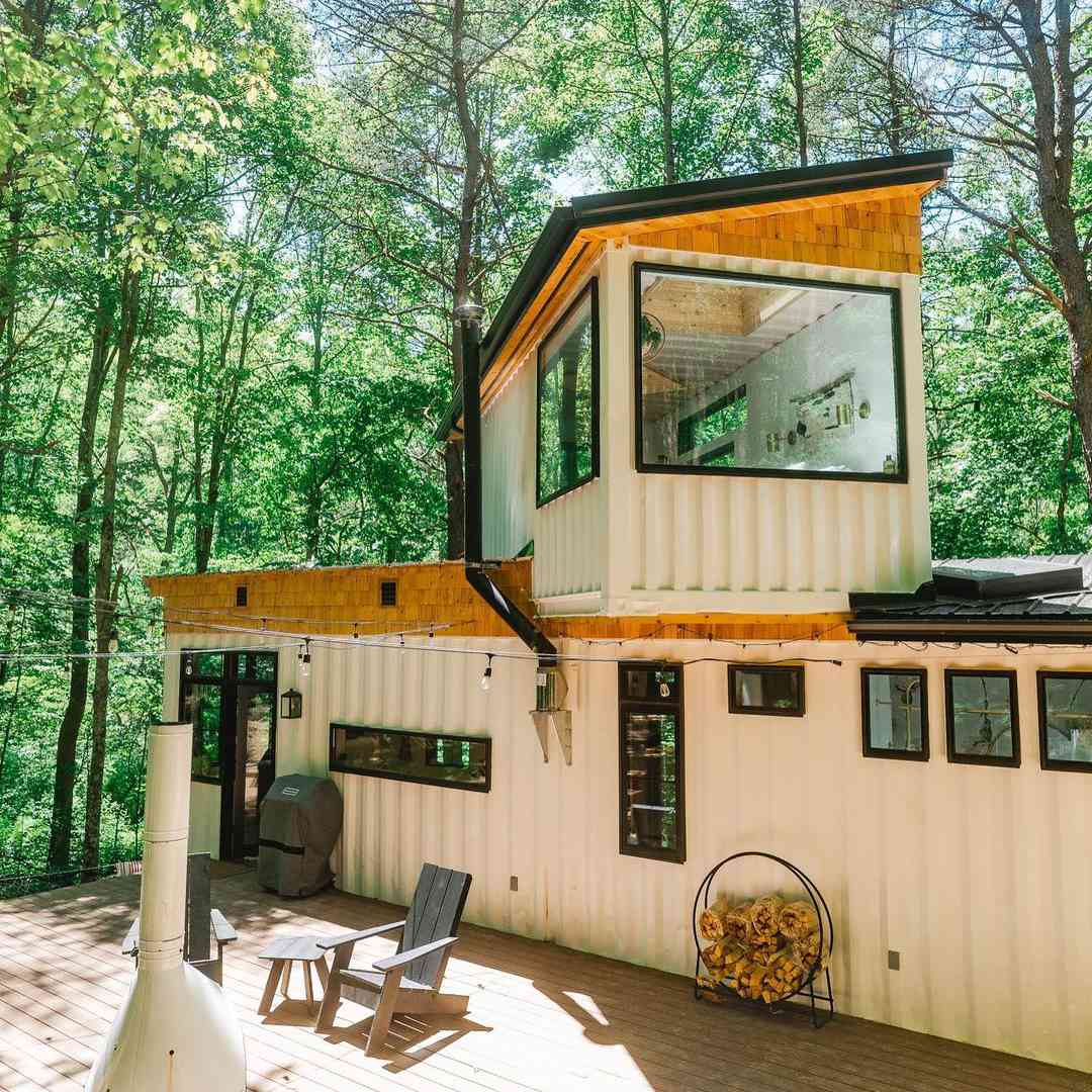 一个小房子的外部有白色油漆和客舱的感觉。