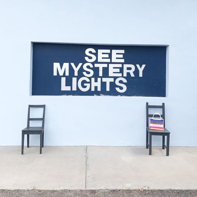 两把椅子坐在一幅壁画下面，上面写着