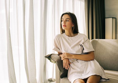 坐在她的长沙发的边缘的妇女