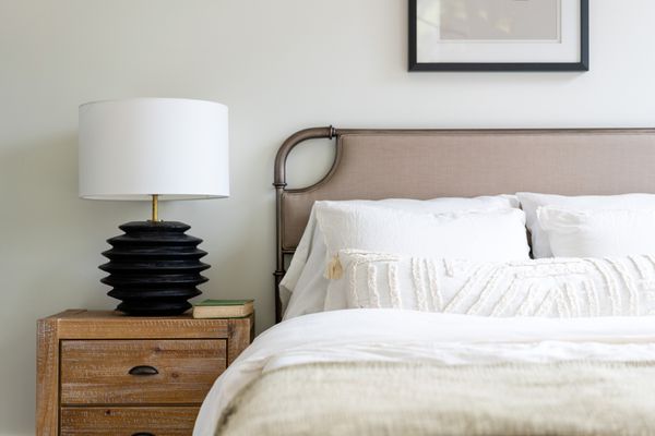 时尚的床和床头柜在现代家庭由阿里哈珀