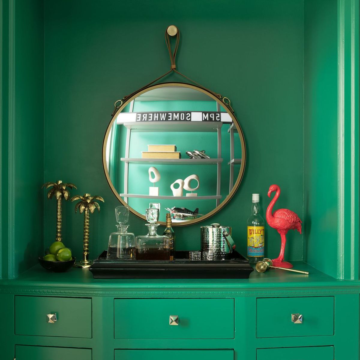 明亮的绿色梳妆台用作酒吧推车。