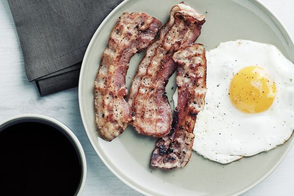 Egg, bacon and black coffee, view from above.