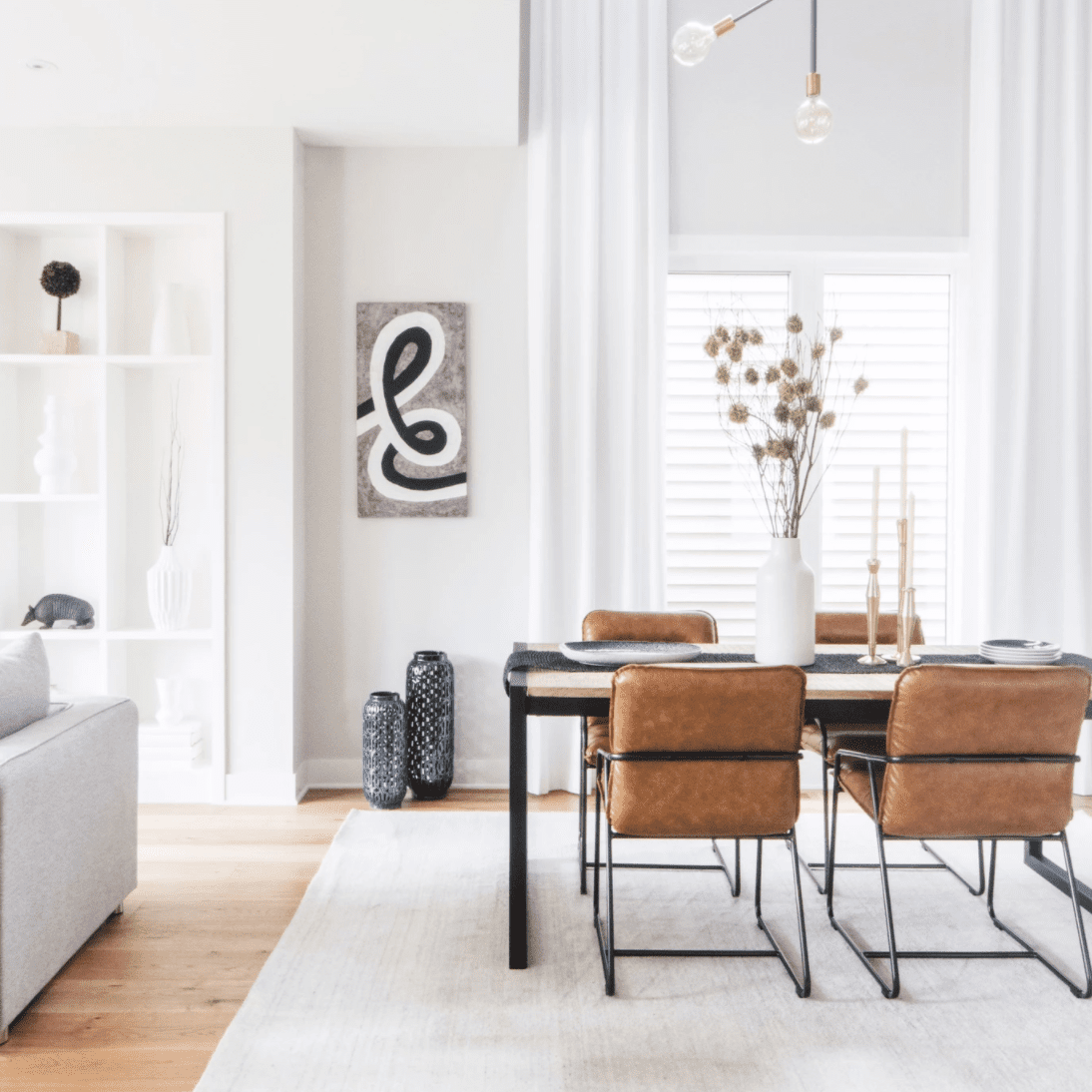 白色的墙壁和挂在特别高的白色窗帘的餐厅