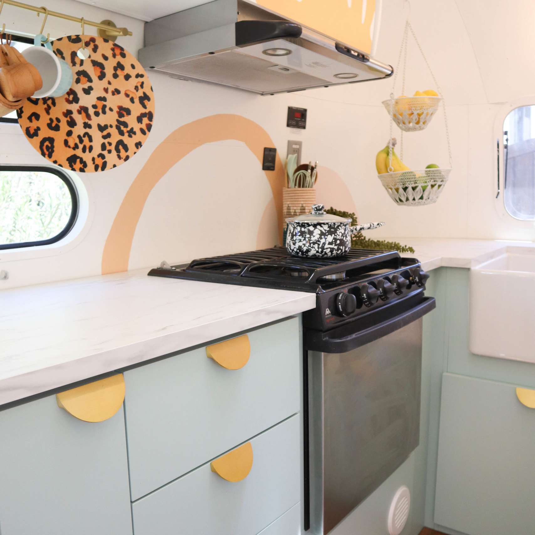 厨房用蓝色橱柜和金色半月形硬件。