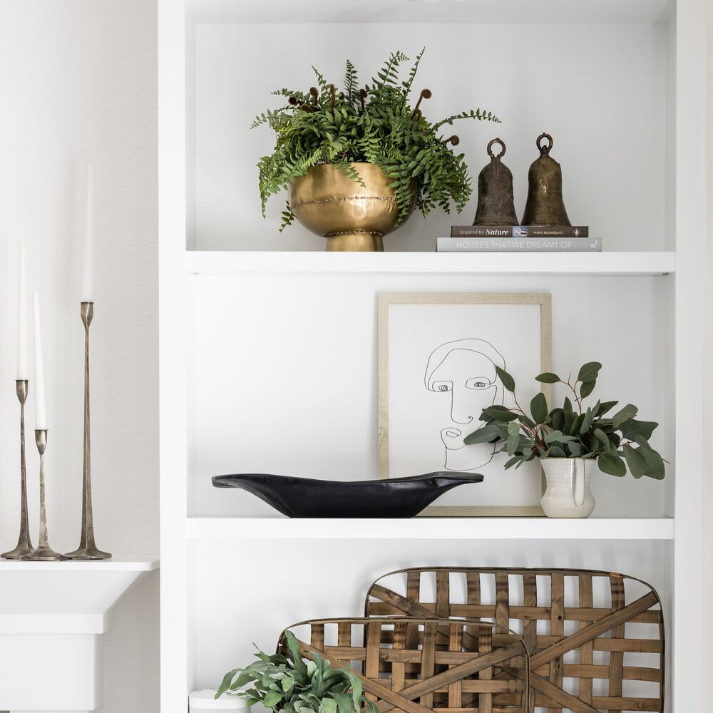 一个白色的橱柜装饰着棕色，黑色和金色装饰 - 加上一些植物