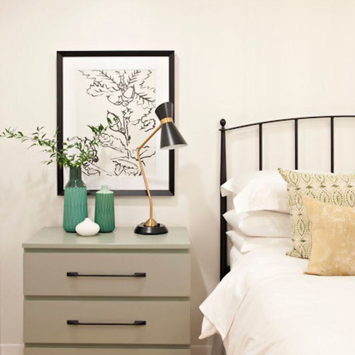 贤哲绿色床头寓在中性床旁边。