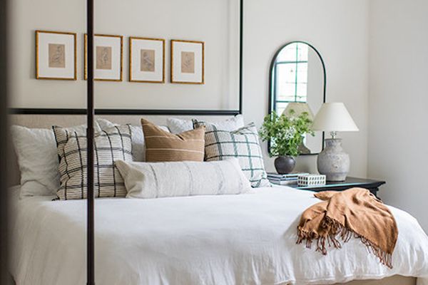 舒适的卧室，天篷床和中性床上用品。